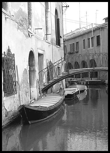 Boats lining the small canals of
                Venice