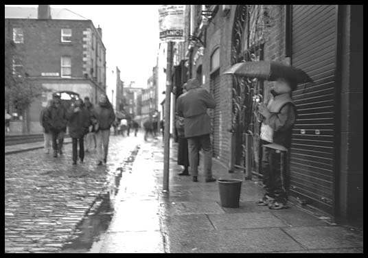 Young boy busking in the Dublin rain